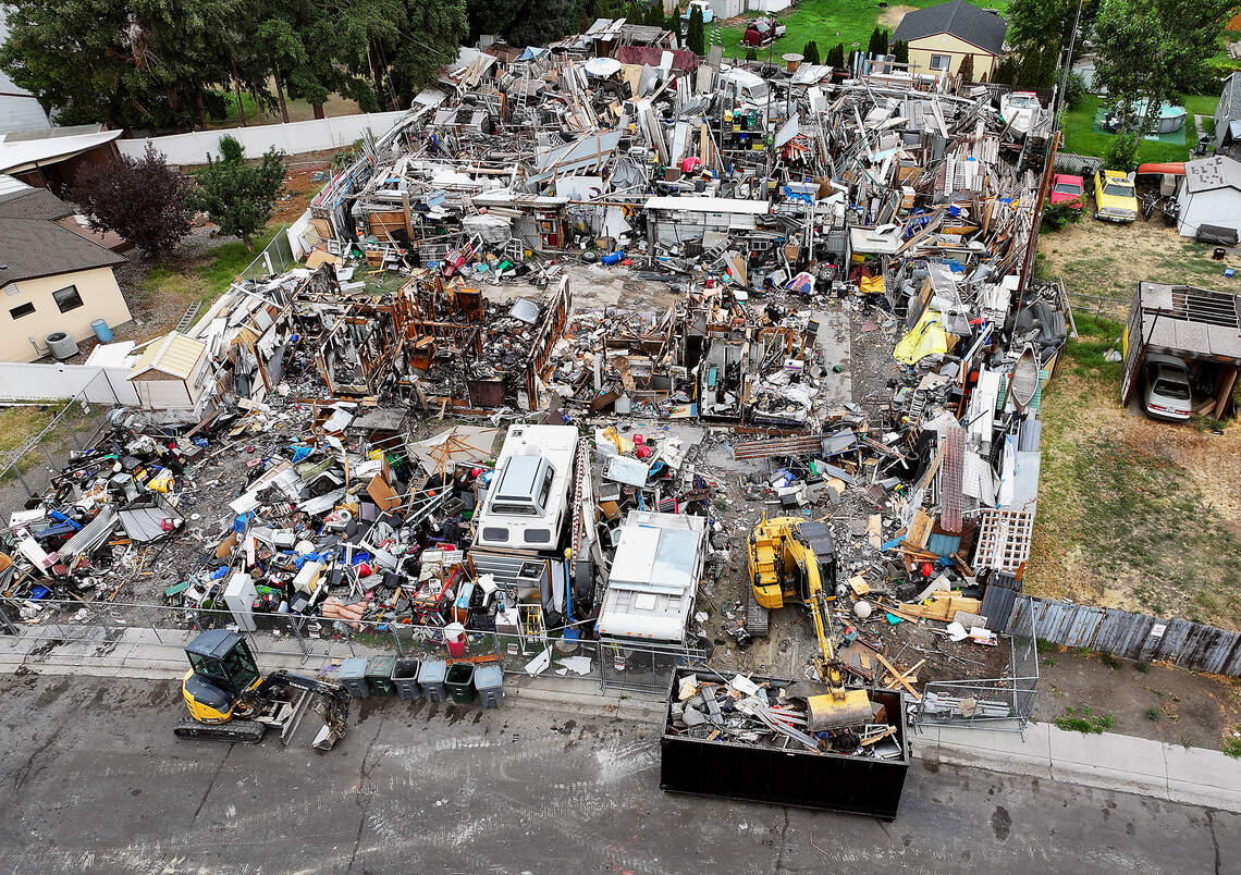 An excavator operated by a local contractor hired by the city of Richland begins cleanup and removal Monday morning of junk, vehicles and debris from 2100 Pullen Street in Richland.
