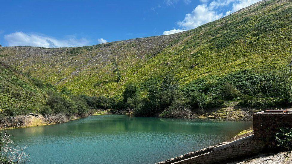 The reservoir has stunning blue waters and is surrounded by a hillside forest