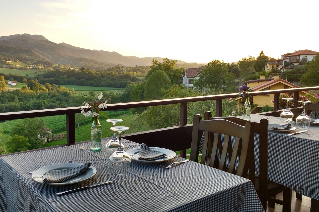 Outdoor dining area with checkered tablecloths and a scenic countryside view