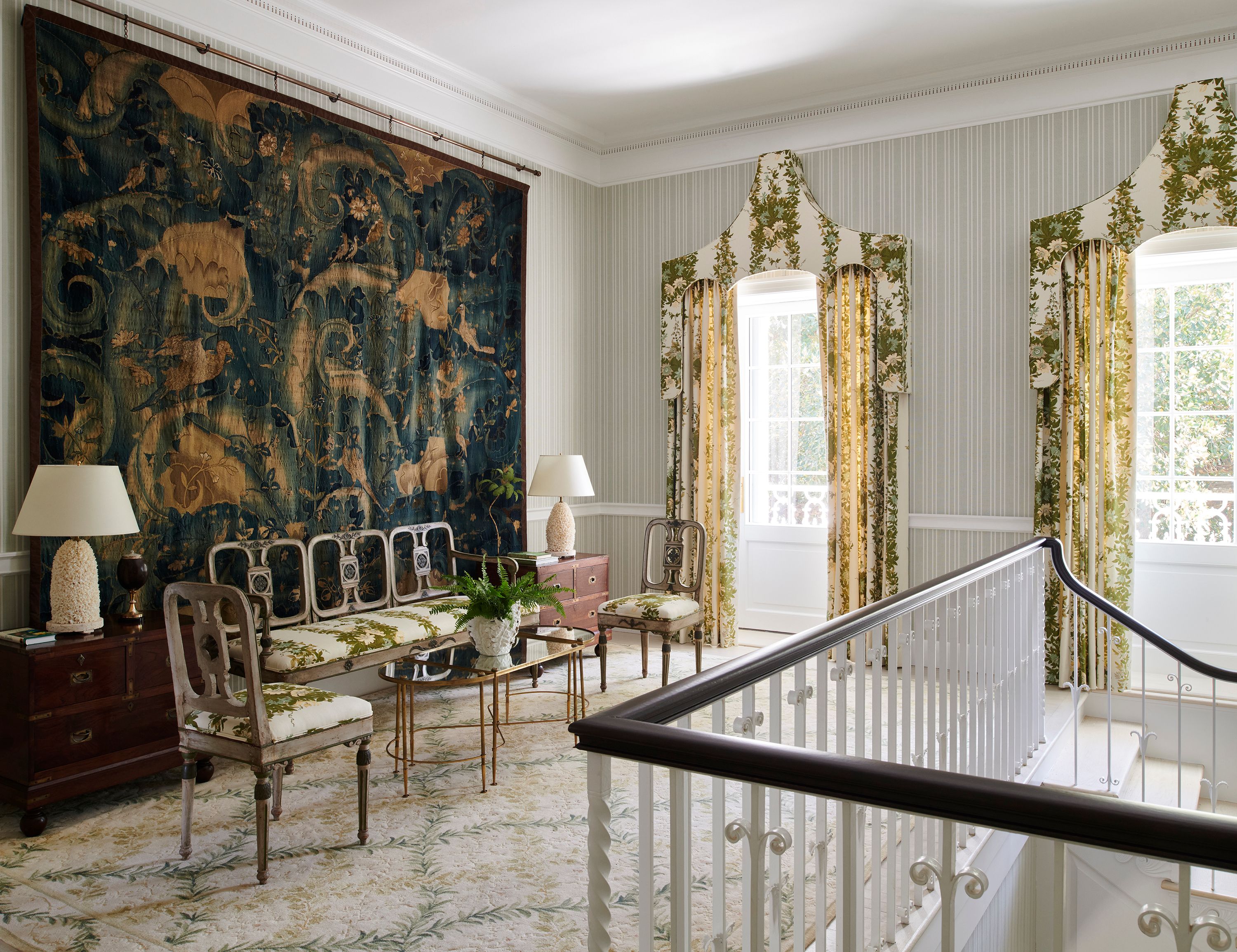 A 17th century Flemish tapestry, unique in that it boasts designs of Florida-appropriate tropical foliage, decorates the landing on the second floor. The curtains and rug continue the theme of flora and fauna. The bench and chairs are antique, as are the chests flanking them.