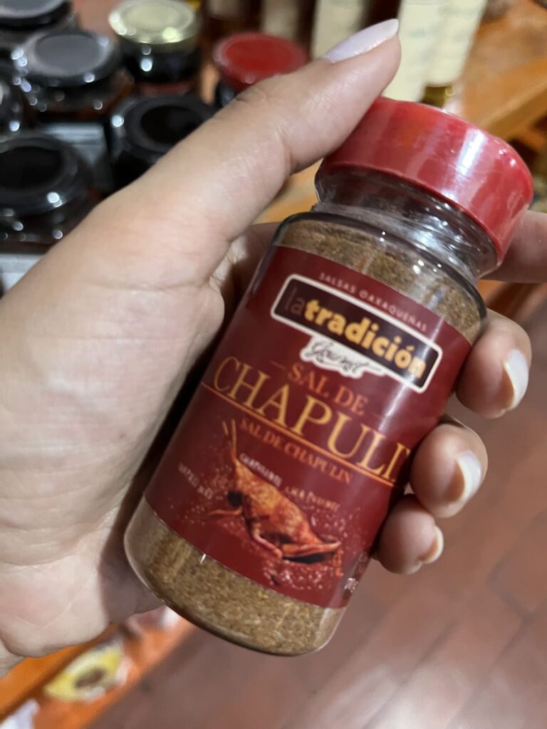 A hand holds a small jar labeled