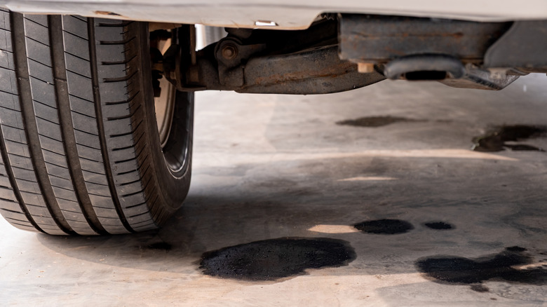 Underside of car with oil leaking on concrete