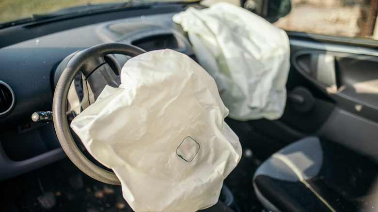 Deployed driver and passenger airbags in what appears to be a first generation Toyota Aygo