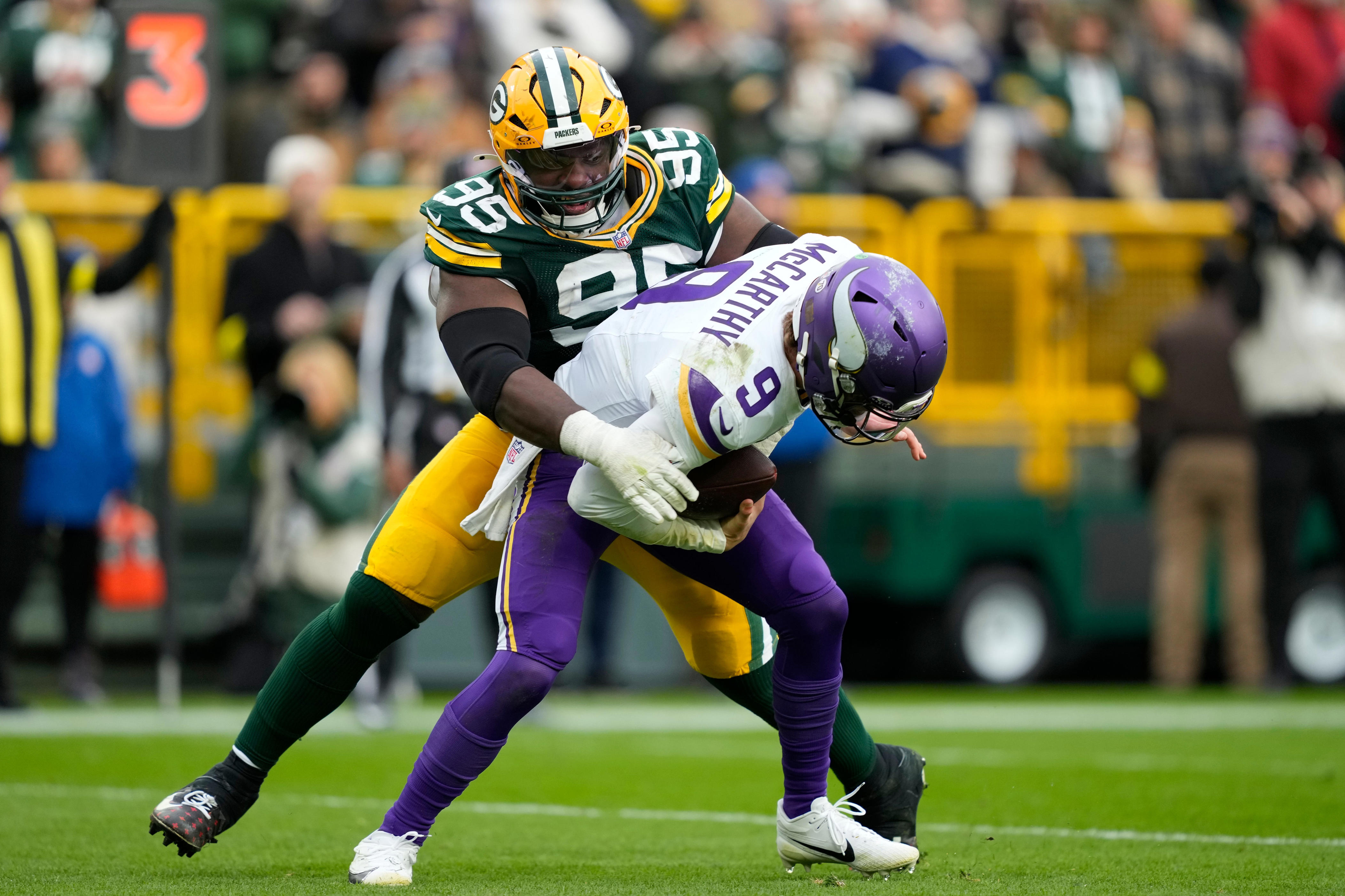Nov 23, 2025; Green Bay, Wisconsin, USA; Minnesota Vikings quarterback J.J. McCarthy (9) is sacked by. Green Bay Packers defensive tackle Devonte Wyatt (95) during the second half at Lambeau Field. Mandatory Credit: Kayla Wolf-Imagn Images