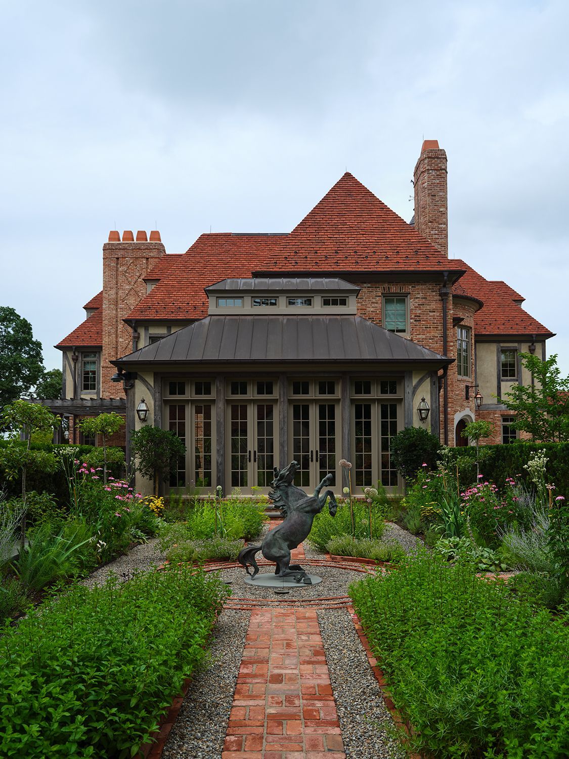 Taking cues from John Russell Pope and Edwin Lutyens, architect James Paragano designed what he calls “a new vernacular English manor country home.” Special attention was given to building materials to portray a historic vision; the clay roof was imported from the UK and new bricks were mixed with repurposed ones. Landscape designer James Doyle crafted English-inspired gardens.