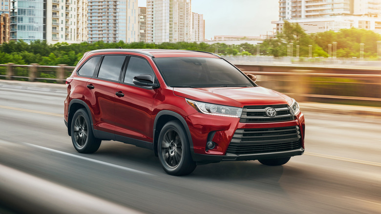 2019 Toyota Highlander driving in cityscape, front-right 3/4 view