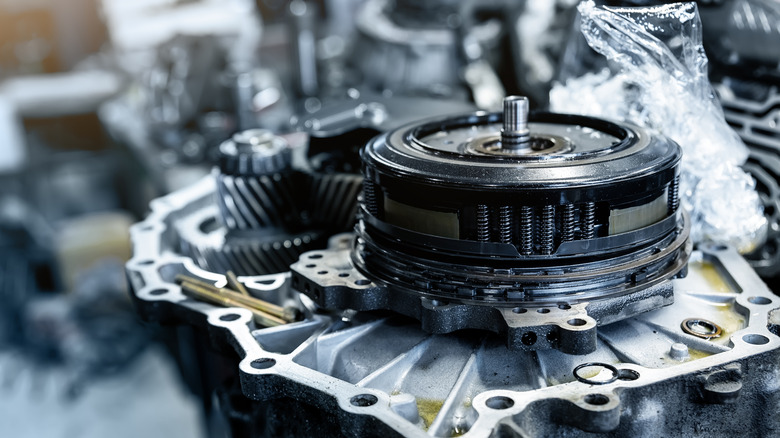Disassembled automatic transmission showing gears and shafts inside bell housing
