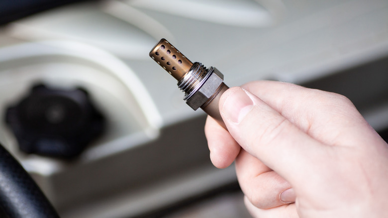 Hand holding new oxygen sensor