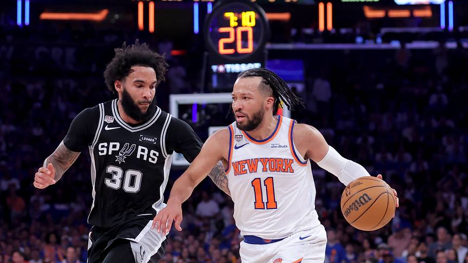 New York Knicks guard Jalen Brunson (11) brings the ball up court against San Antonio Spurs forward Julian Champagnie (30).