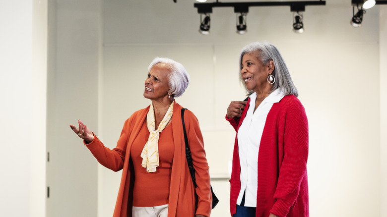 Two women admiring and discussing art.