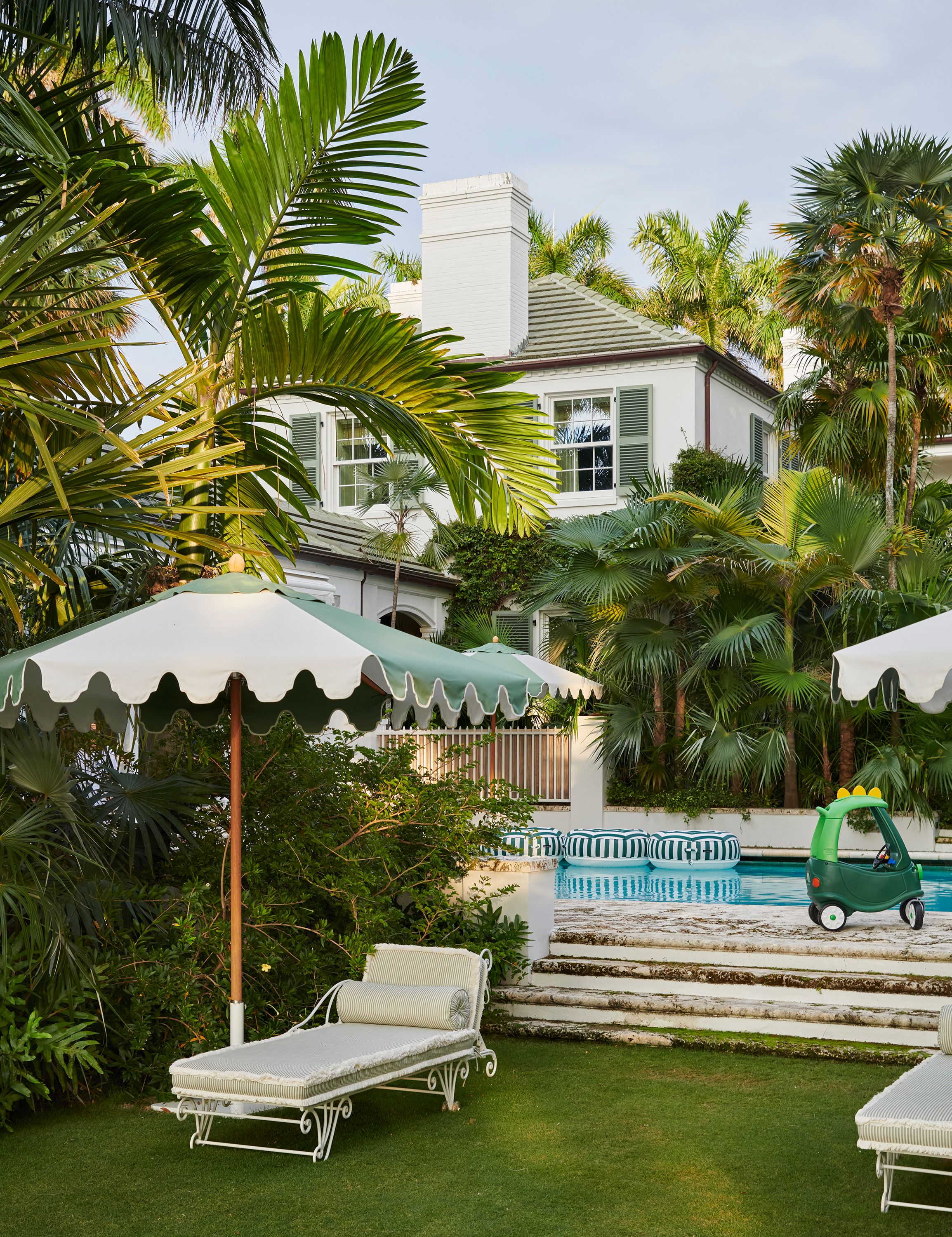 The pool serves as another party area, surrounded by palms native to the region and toys for the couple’s young son.