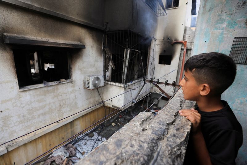 Palestinians inspect the site of an Israeli strike on a house in Gaza City