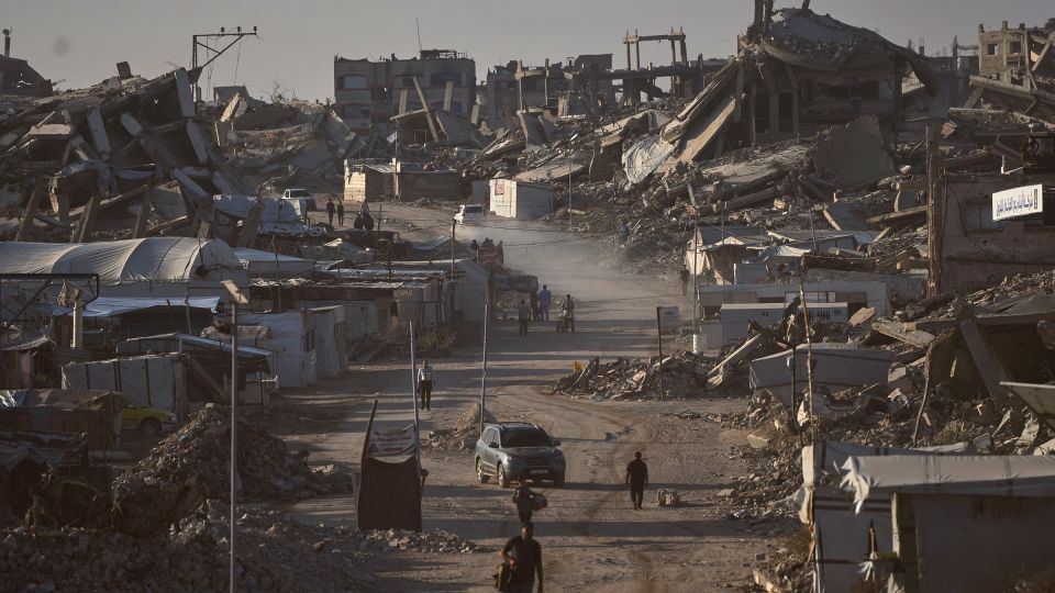 Palestinians walk along a road surrounded by buildings destroyed in Israeli military strikes during the Israel-Hamas war, in Jabaliya, Gaza Strip, on July 2, 2026. - Jehad Alshrafi/AP