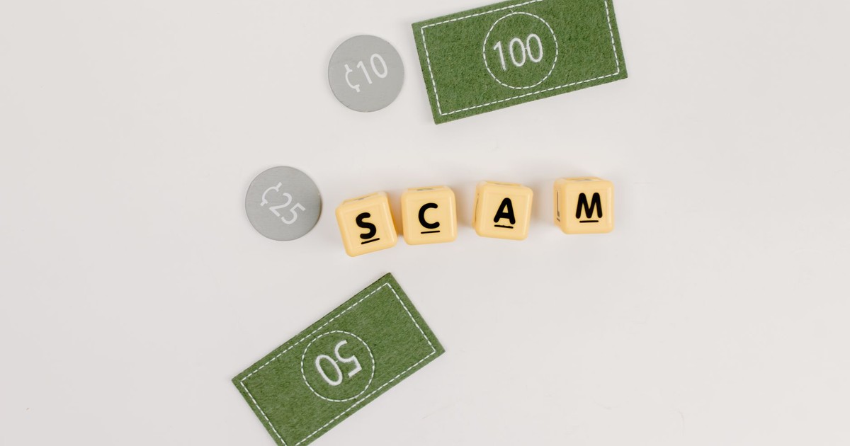 Flat lay of fake currency and scam letters on a gray surface representing financial deception.