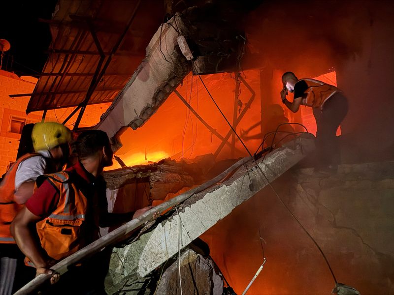 Civil Defence personnel respond following an Israeli strike on a residential apartment in Gaza City