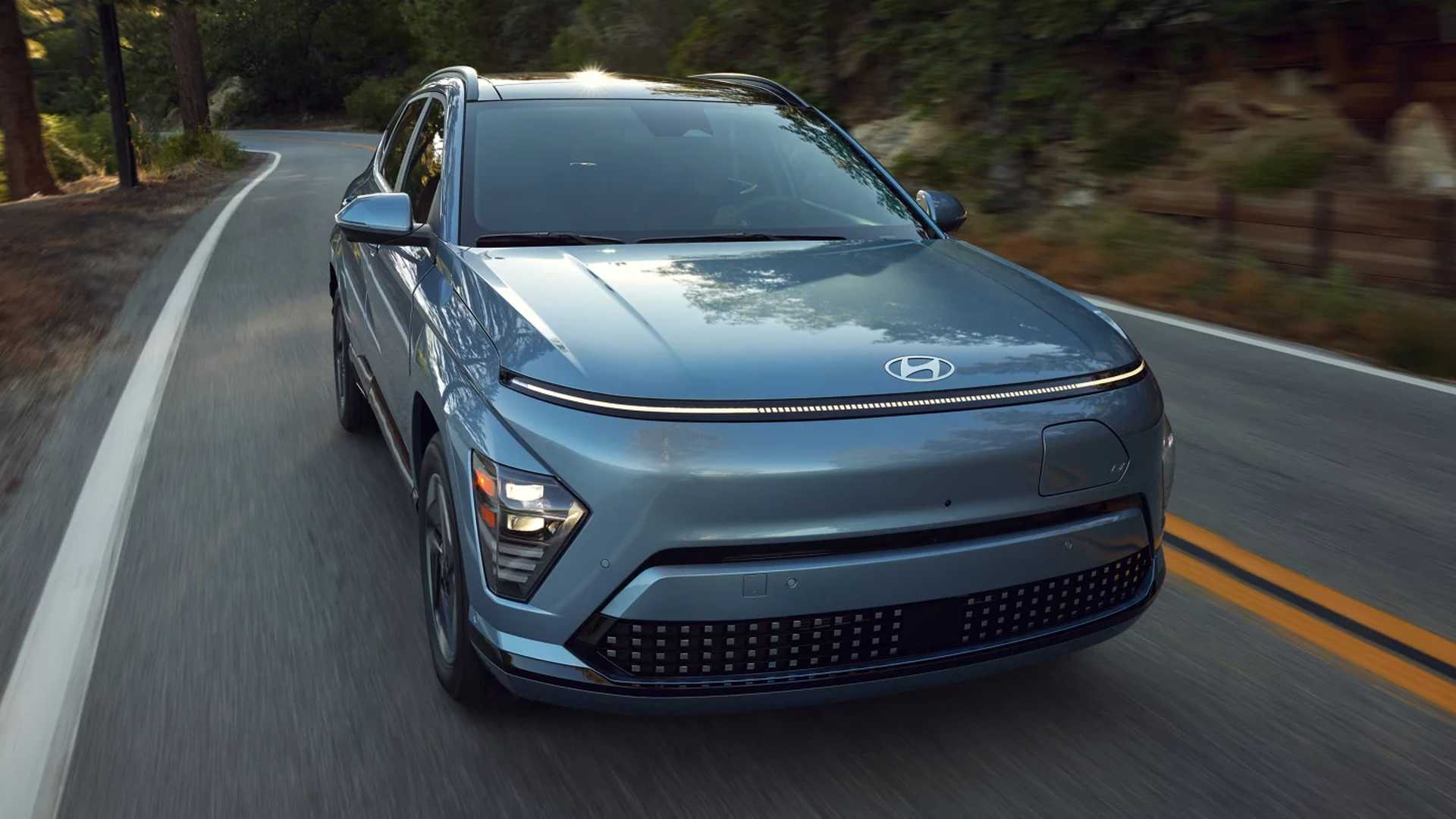 2024 Hyundai Kona Electric driving on a two lane road in the mountains