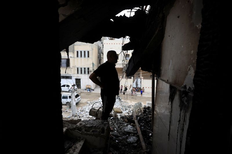 Palestinians inspect the site of an Israeli strike on a house in Gaza City