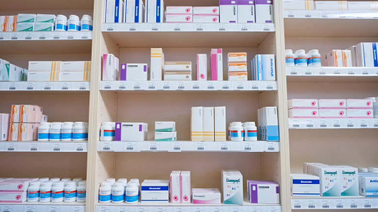 Shelves stacked with drug bottles in a pharmacy