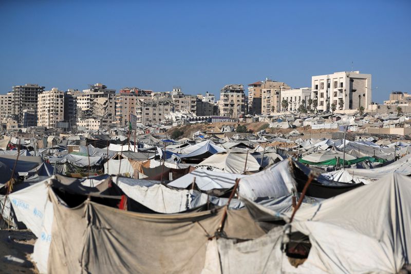Wastewater flows next to tents sheltering displaced Palestinians, in Gaza