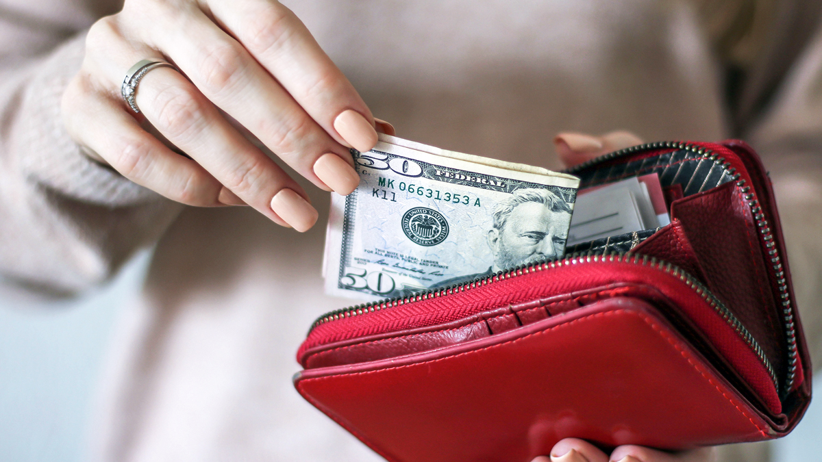 Womans hands taking money out of wallet