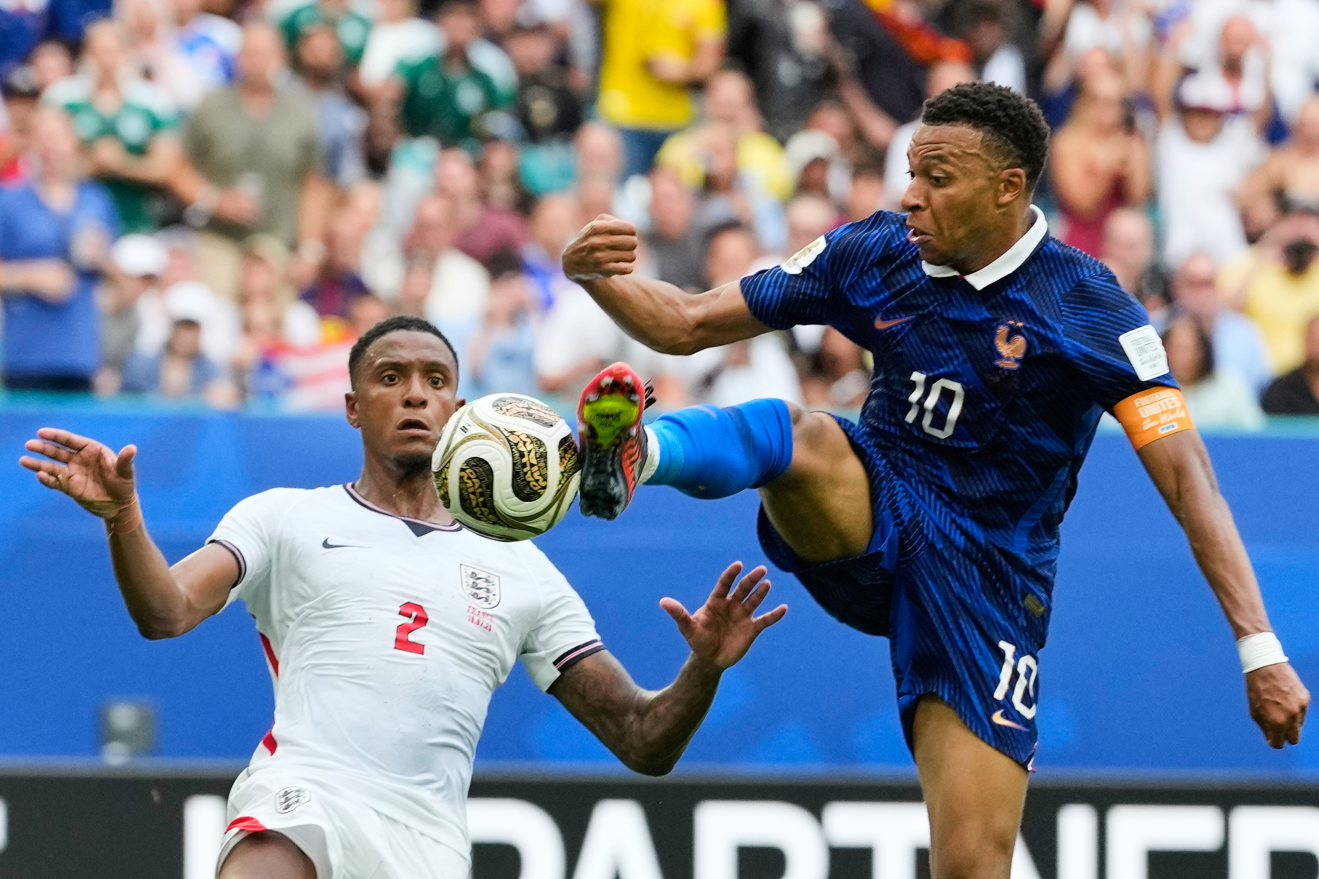 France's Kylian Mbappe (10) takes a shot as England's Ezri Konsa (2) defends during the World Cup third-place playoff soccer match between France and England in Miami Gardens, Fla., Saturday, July 18, 2026. (AP Photo/Rebecca Blackwell)
