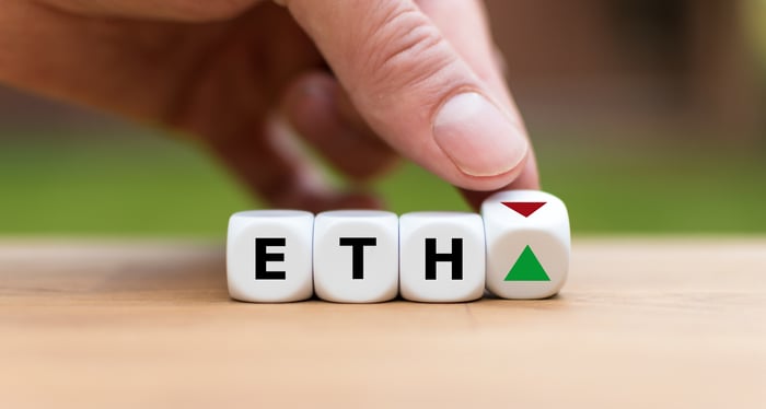 The letters "ETH" are etched onto three dice, with a fourth dice showing an up arrow and a down arrow.