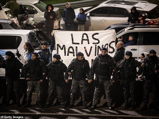Fans of Argentina display a banner as officers guard them while they wait for players and coaching staff of Argentina to arrive at Predio Lionel Andres Messi after losing the FIFA World Cup 2026 final against Spain, on July 20, 2026 in Ezeiza, Argentina