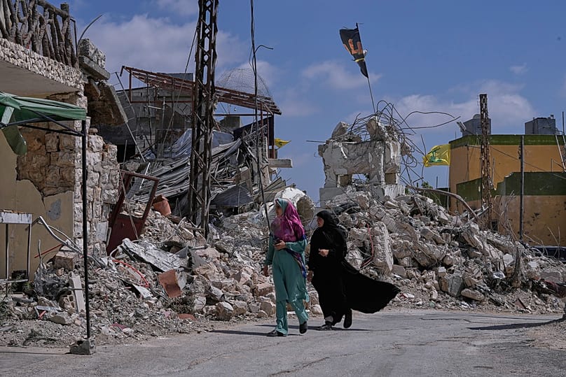 Lebanese women pass by houses that were destroyed in Israeli strikes during the war with Hezbollah in Froun village, southern Lebanon, Thursday, July 16, 2026