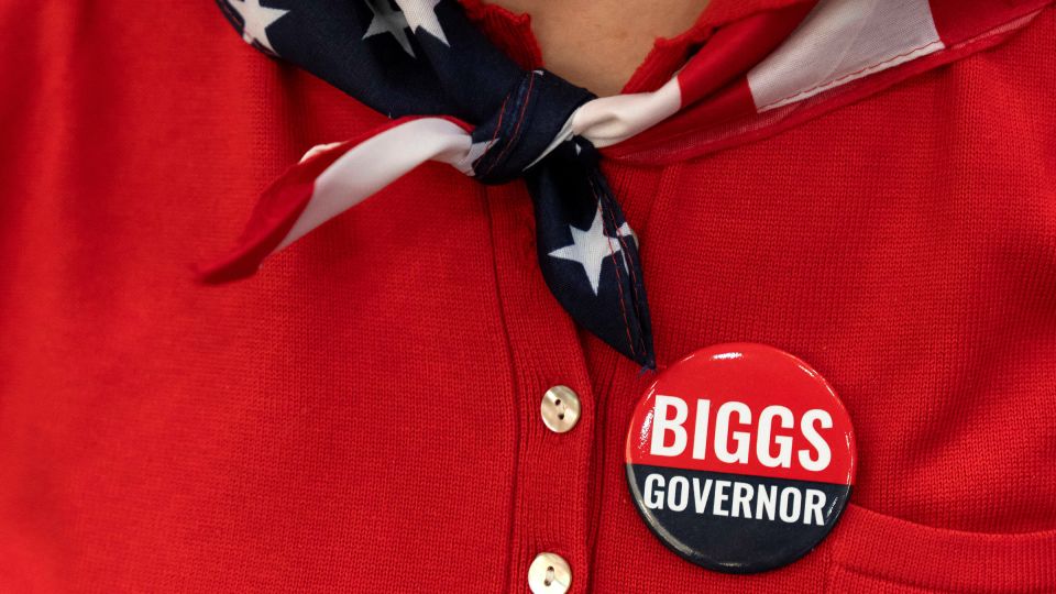 A woman sports a campaign button that reads “Biggs Governor” during a rally in support Rep. Andy Biggs in Gilbert, Arizona, July 17. - Rebecca Noble/Reuters