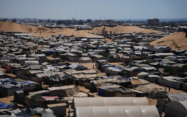 Displaced Palestinians walk between tents where they are taking shelter at a makeshift camp in Khan Younis, southern Gaza Strip, July 1, 2026. (Abdel Kareem Hana/AP)