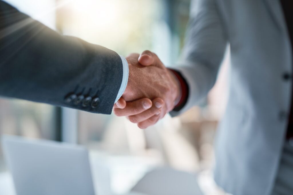 Meeting, handshake and business people in partnership for deal, welcome or onboarding for b2b collaboration. Office, teamwork and shaking hands for agreement, consulting or introduction with trust