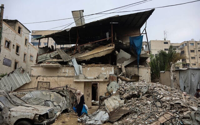 A Palestinian woman walks past debris at the site of an Israeli air strike in Gaza City on July 21, 2026. (Omar AL-QATTAA/AFP)