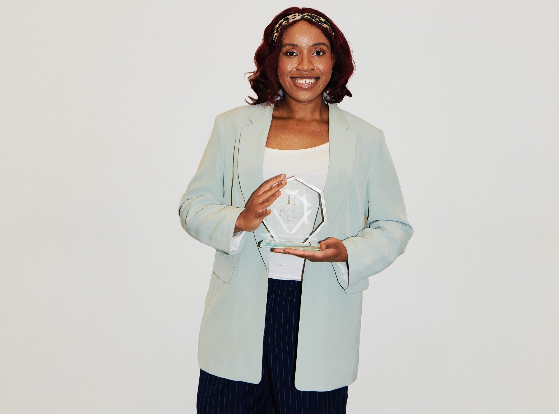 Erica James smiling and holding an award