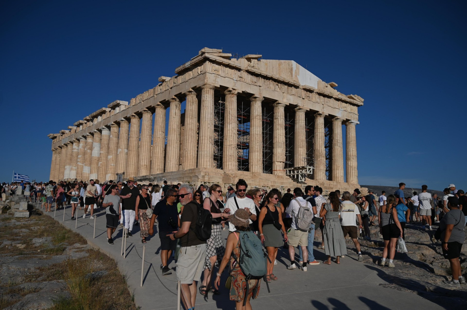 An image of the exterior of the Acropolis in Greece surrounded by tourists.