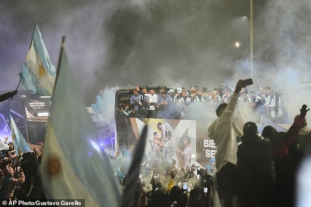 Argentina coach Lionel Scaloni, center, surrounded by team members, waves to fans from a bus heading to the Argentine Football Association headquarters in Ezeiza, on the outskirts of Buenos Aires, Monday, July 20, 2026