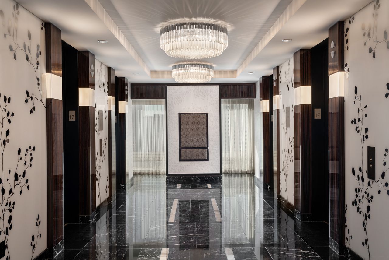 Elevator landing area at the Waldorf Astoria Las Vegas with chandeliers and decor