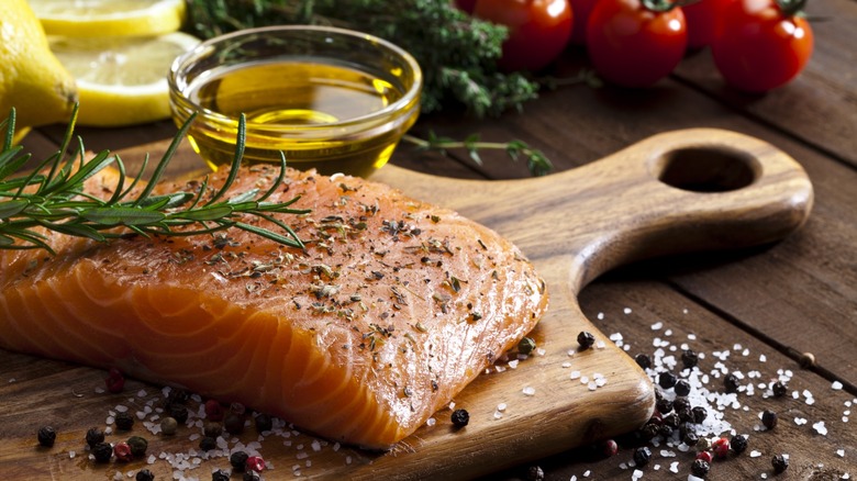 raw, seasoned salmon on wooden board