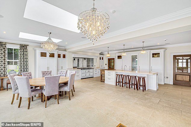 The property features a large white kitchen decorated with chandeliers and characterful touches