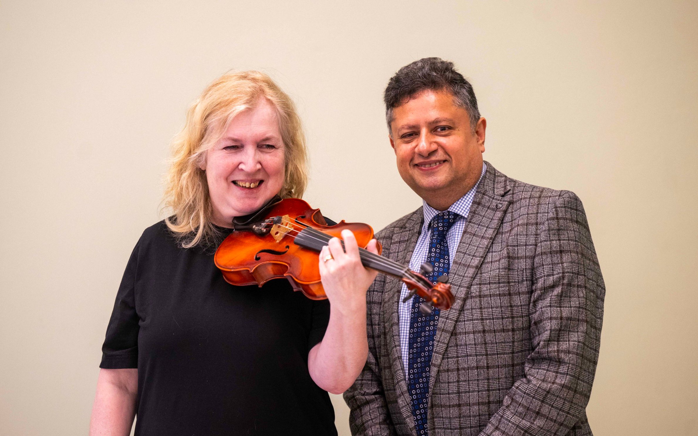 Dagmar Turner holding the violin with Prof Keyoumars Ashkan
