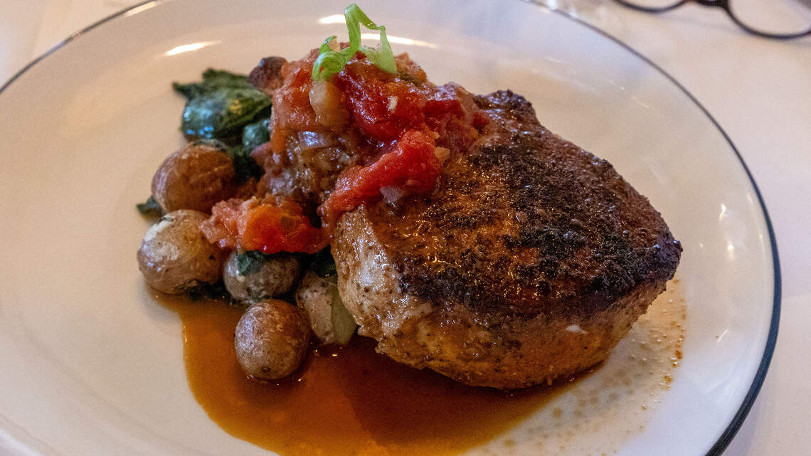 The 16-oz. bone-in Duroc Pork Chop ($48) at The V at the Vine is served with spinach, potato and tomato jam.