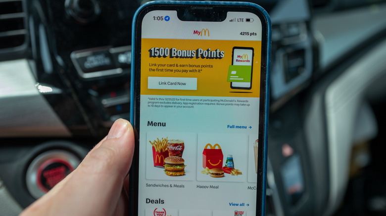 A phone displays the McDonald's app, with