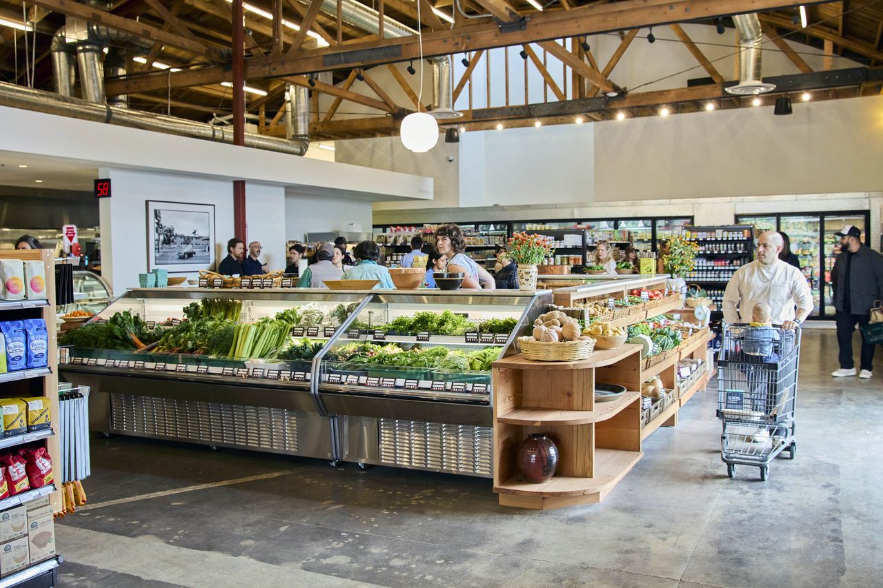 Interior of a grocery store with people shopping and an assortment of produce on display