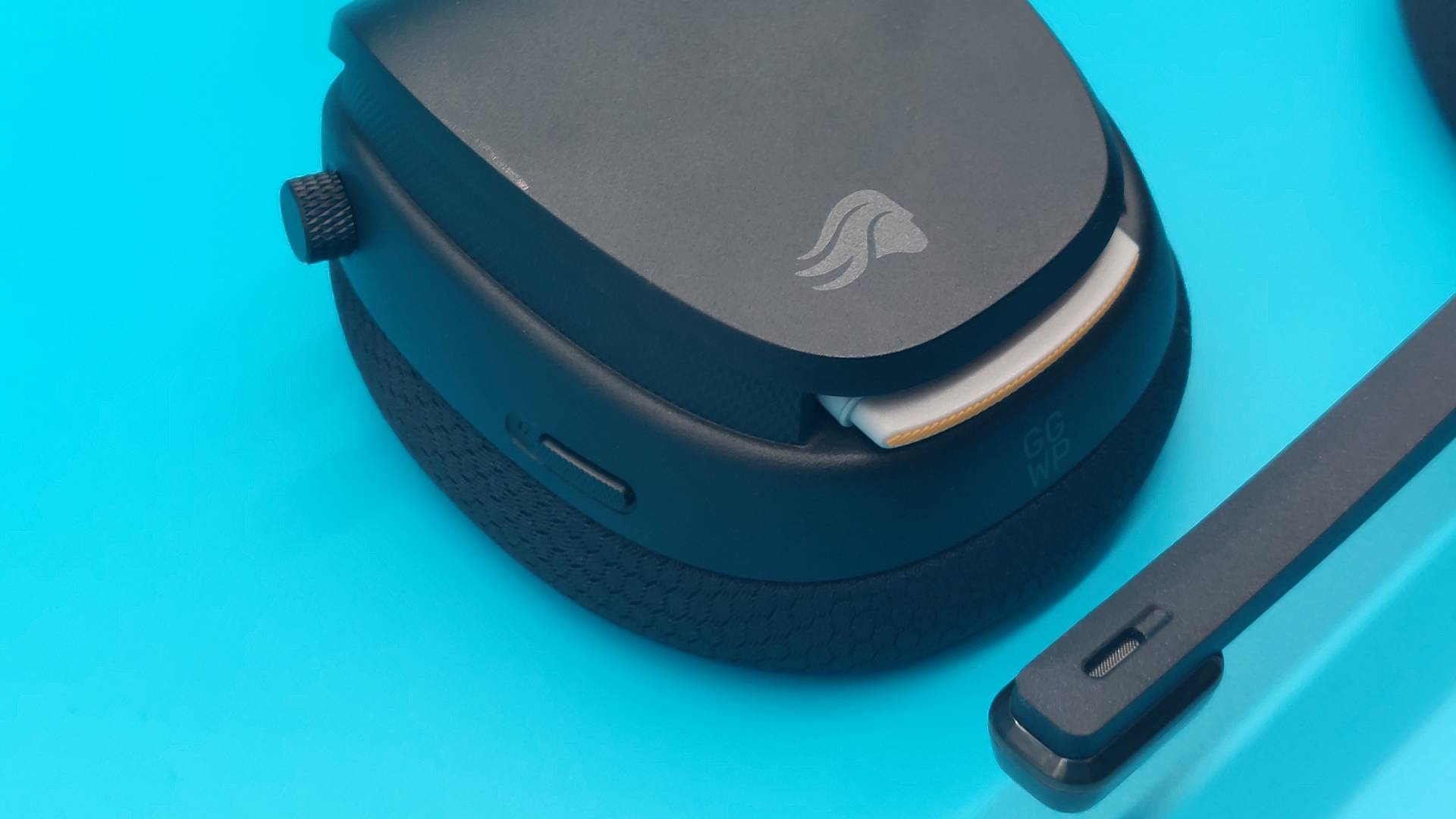 The GHS Wireless InfinitePlay seen from various angles on a blue background. This is a wireless gaming headset from Glorious. It is black all over, save for a few subtle orange accents.