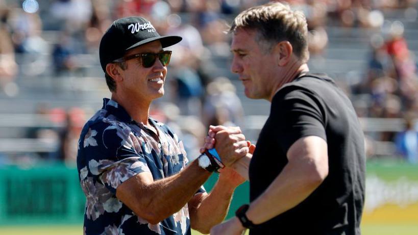 Phil Parkinson (right) shakes hands with Wrexham co-owner Rob Mac during the club's last pre-season tour to the States in 2024