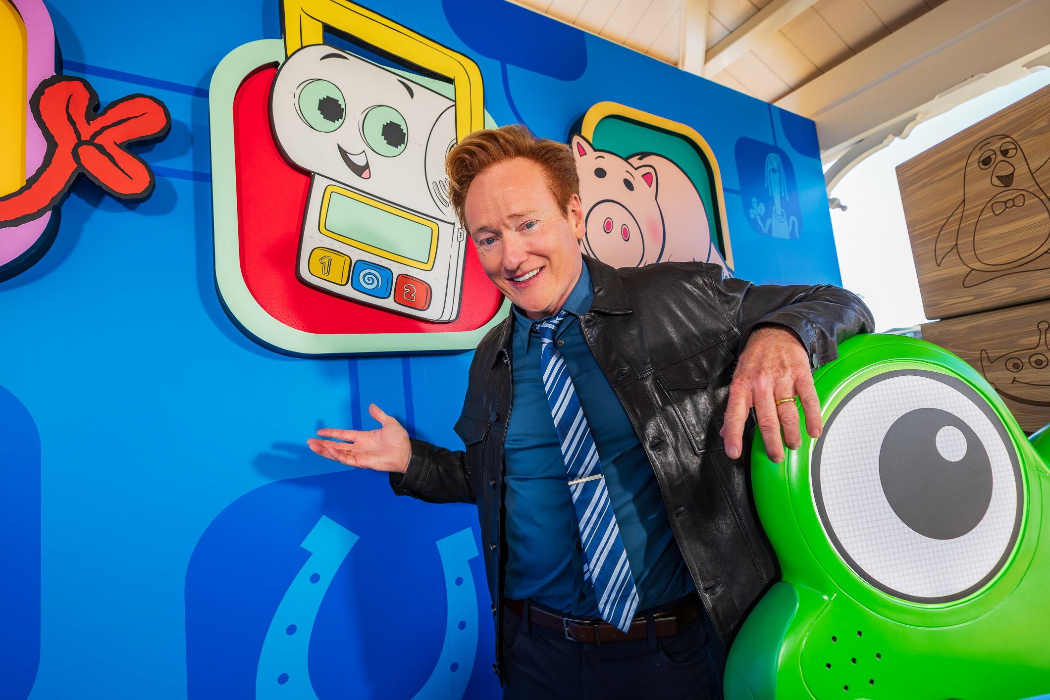 Conan O'Brien, voice of Smarty Pants, poses next to characters from Pixar's Toy Story.