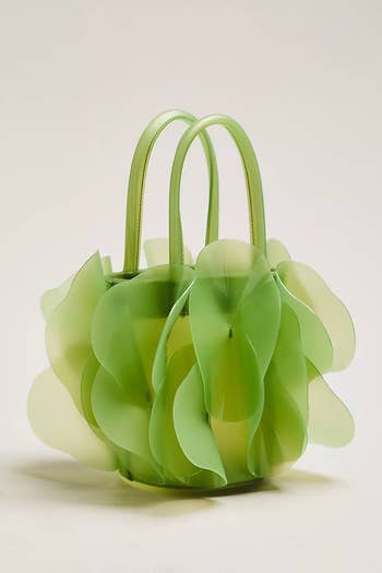 A stylish handbag with leaf-like designs, featuring layered, petal-shaped accents, perfect for a fashionable shopping statement