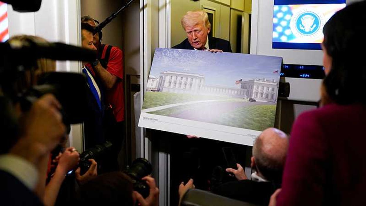 U.S. President Donald Trump talks to members of the media while holding up renderings of planned White House ballroom, aboard Air Force One U.S., March 29, 2026. REUTERS/Elizabeth Frantz