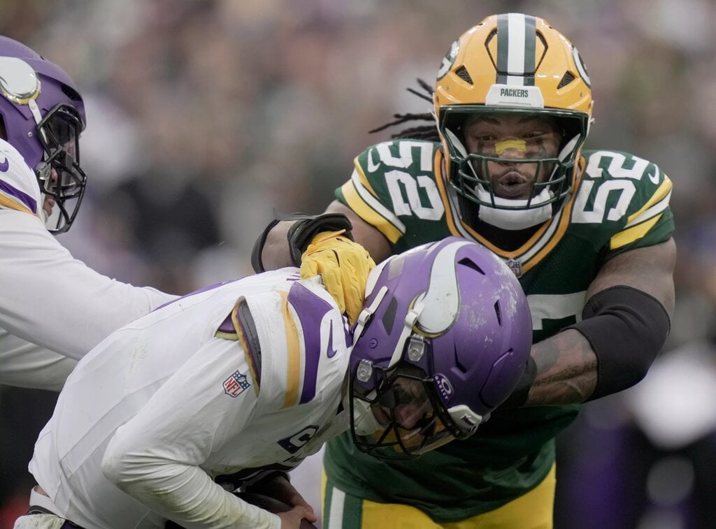 Minnesota Vikings’ J.J. McCarthy (9) evades a sack by Green Bay Packers defensive end Rashan Gary (52) during the fourth quarter of their game Sunday, November 23, 2025 at Lambeau Field in Green Bay, Wisconsin. The Green Bay Packers beat the Minnesota Vikings 23-6.
