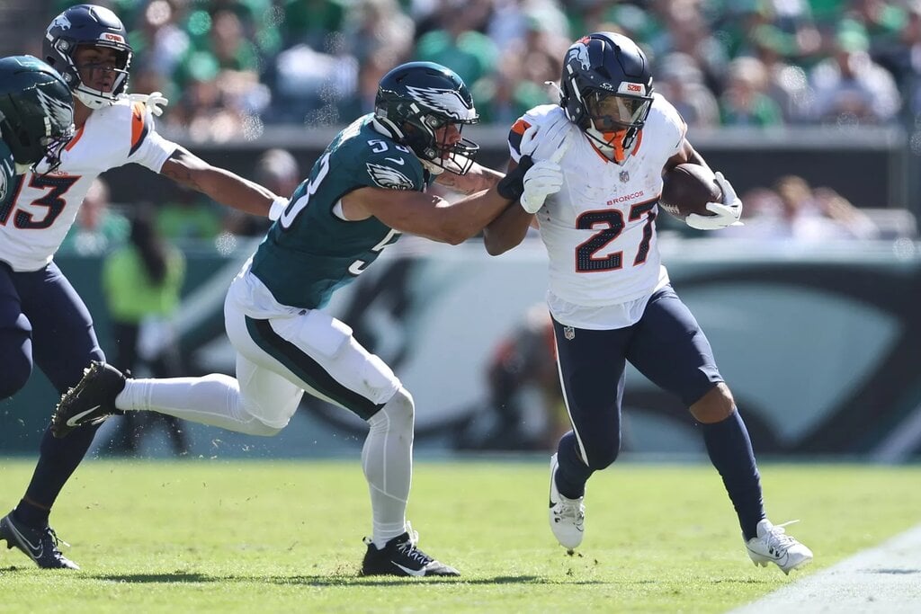 Oct 5, 2025; Philadelphia, Pennsylvania, USA; Denver Broncos running back J.K. Dobbins (27) runs against Philadelphia Eagles linebacker Zack Baun (53) in the second quarter at Lincoln Financial Field. Mandatory Credit: Bill Streicher-Imagn Images