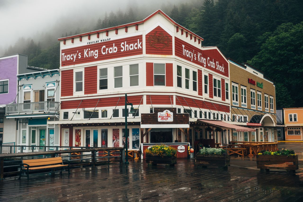 Tracy's King Crab Shack restaurant in a quaint wooden building on a boardwalk, surrounded by other structures and trees